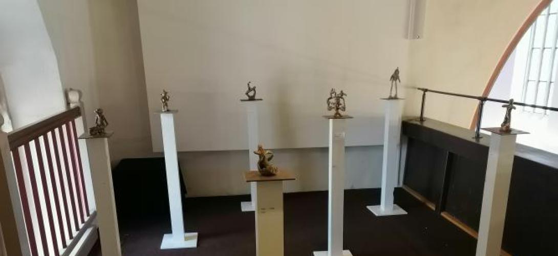 kleine Bronzefiguren auf Socke in einem Ausstellungsraum